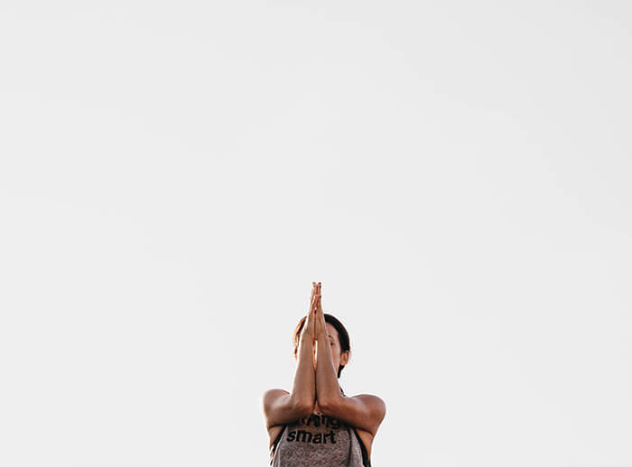 woman doing yoga with arms crossed in front of her